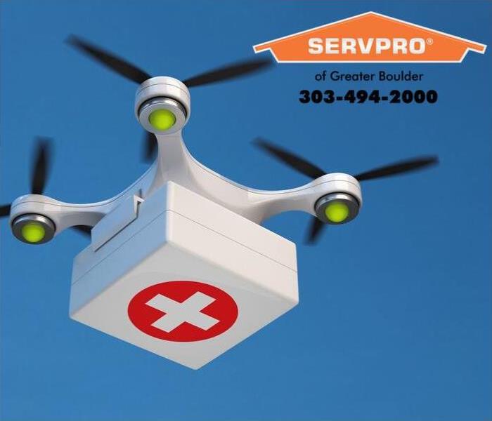 Flying drone transporting an emergency kit.